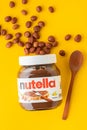 KYIV, UKRAINE - February 21: Nutella chocolate hazelnut spread in a glass jar with white cap next to wooden spoon and raw