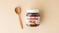 KYIV, UKRAINE - February 22: Nutella chocolate hazelnut spread in a glass jar with white cap next to wooden spoon and raw