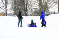 Kyiv, Ukraine. January 3, 2021. Family with kid in snowy park. Sleigh in winter.