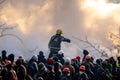 Kyiv, Ukraine - January 23, 2014:A firefighter puts out a fire during protests in Kyiv