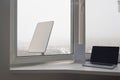KYIV, UKRAINE - JANUARY 24, 2023: Starlink wi-fi router and laptop on windowsill at home with Starlink antenna behind