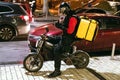 Kyiv, Ukraine - January 24, 2020. Yaroslaviv Val. Food delivery courier with big yellow backpack sitting on scooter