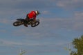 A brave biker jumps very high on a motorcycle and performs a stunt. Royalty Free Stock Photo