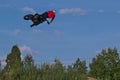 A brave biker jumps very high on a motorcycle and performs a stunt.