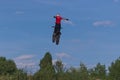 A brave biker jumps very high on a motorcycle and performs a stunt.