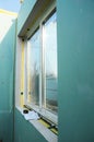 PVC window installation in a frame panel house with mineral glass insulation