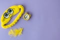 Sponge Bob themed sleep mask next to yellow alarm clock on a violet background