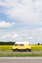 Kyiv, Ukraine - July 2019: Woman riding camper van car through sunflower field on summer day