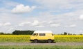 Kyiv, Ukraine - July 2019: Woman riding camper van car through sunflower field on summer day