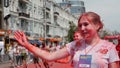 Kyiv/Ukraine - June 2, 2019 - Attractive female volunteer at Color Run stained in bright fluorescent holi paints standing at finis