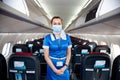 Kyiv, Ukraine - June 27, 2020: A flight attendant and a stewardess in a medical mask in the cabin of a Windrose airline prepares