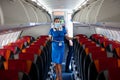 Kyiv, Ukraine - June 27, 2020: A flight attendant and a stewardess in a medical mask in the cabin of a Windrose airline prepares
