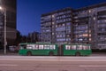 Green trolleybus on the street of Kyiv in the residential area of Troyeschina at night. Trolleybus \