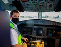 Kyiv, Ukraine - June 27, 2020: Masked pilot. Instrument panel and steering wheel in the cockpit. Plane Windrose airline Aircraft