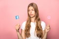 KYIV, UKRAINE - JUNE 7, 2019: girl holding facebook and instagram signs on sticks isolated on pink