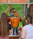 A street saleswoman pours a fruit cocktail with ice during a record hot day.