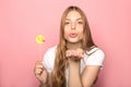 KYIV, UKRAINE - JUNE 7, 2019: woman blowing kiss holding emoji isolated on pink