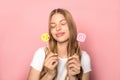 KYIV, UKRAINE - JUNE 7, 2019: woman holding emoji blowing kiss and Instagram sign isolated on pink