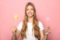 KYIV, UKRAINE - JUNE 7, 2019: woman holding emoji blowing kiss and Instagram sign isolated on pink