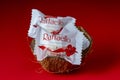 Ferrero Raffaello premium sweets produced by Italian chocolatier Ferrero SpA in coconut husk on red background. Raffaello candies