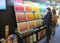 Adult women choosing exterior decorating paint for house in shopping mall. Painting department at hardware store.