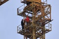 A group of high-rise assemblers work on the top floor of a construction crane.