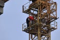 A group of high-rise assemblers work on the top floor of a construction crane.