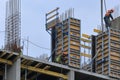 A group of high-rise assemblers work on the top floor of a construction site.