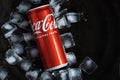 Close up shot of classic Coca-Cola red can in the pile of ice cubes on the black background. Popular