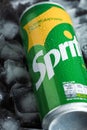 Close up shot of classic Sprite can in the pile of ice cubes on the black background. Popular beverage of