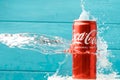 Close up shot of water splash over classic Coca-Cola red can on the turquoise wooden background. Popular Royalty Free Stock Photo