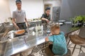 Cooking chef and kitchener making food for small boy at open space kitchen of modern restaurant