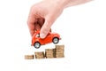 View of man holding red toy car above coins isolated on white Royalty Free Stock Photo