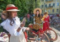 Group of women in old fashion dresses ready for cycling with vintage bicycle during outdoor festival Retro Cruise