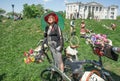 Older woman in old fashion dress with retro bicycle having fun under sun of outdoor festival Retro Cruise