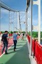 Kyiv, Ukraine - May 18, 2019. Park bridge over the Dnipro river. People walking along the pedestrian bridge on weekend