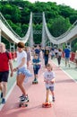 Kyiv, Ukraine - May 18, 2019. Park bridge over the Dnipro river. People walking along the pedestrian bridge on weekend