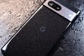 KYIV, UKRAINE - October 03, 2023 : Modern smartphone Google Pixel with water drops on black background. Water resistant modern