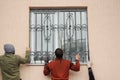 KYIV, UKRAINE - October, 02, 2019: Worker install window iron security bars for house safety. Contractors installing window iron