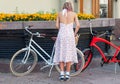 One young woman with bicycle in bright vintage clothing ready for festival Retro Cruise