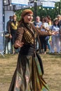 A Georgian woman from a group of ethnic dancers from the country of Georgia perform in the open air.