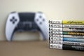 KYIV, UKRAINE - SEPTEMBER 17, 2025 Stack of PS5 videogame disc boxes and modern dualsense edge gamepad Royalty Free Stock Photo