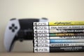 KYIV, UKRAINE - SEPTEMBER 17, 2025 Stack of PS5 videogame disc boxes and modern dualsense edge gamepad Royalty Free Stock Photo