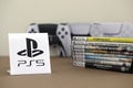KYIV, UKRAINE - SEPTEMBER 17, 2025 Stack of PS5 videogame disc boxes and modern dualsense edge gamepad. PS5 logo in front Royalty Free Stock Photo