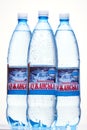 Kyiv, Ukraine, 04.04.2020: three juicy bottles of the Luzhanska mineral water with drops on a white background with reflection. Royalty Free Stock Photo