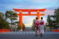 Young Japanese woman in traditional Yukata dress stroll by the gigantic great torii gate of Heian Jingu shrine in Kyoto, Japan Royalty Free Stock Photo