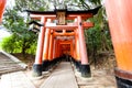 Kyoto, Japan - December 27, 2009: Tourists walking near orange wooden torii tunnel in Fushimi Inari Taisha Shrine