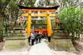 Kyoto, Japan - December 27, 2009: Tourists walking near Orange wooden torii tunnels in Fushimi Inari Taisha Shrine