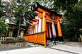 Kyoto, Japan - December 27, 2009: Woman walking near orange wooden torii tunnel in Fushimi Inari Taisha Shrine