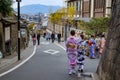 Colorful young japanese girls dressed in traditional kimonos walking down a street in Gion